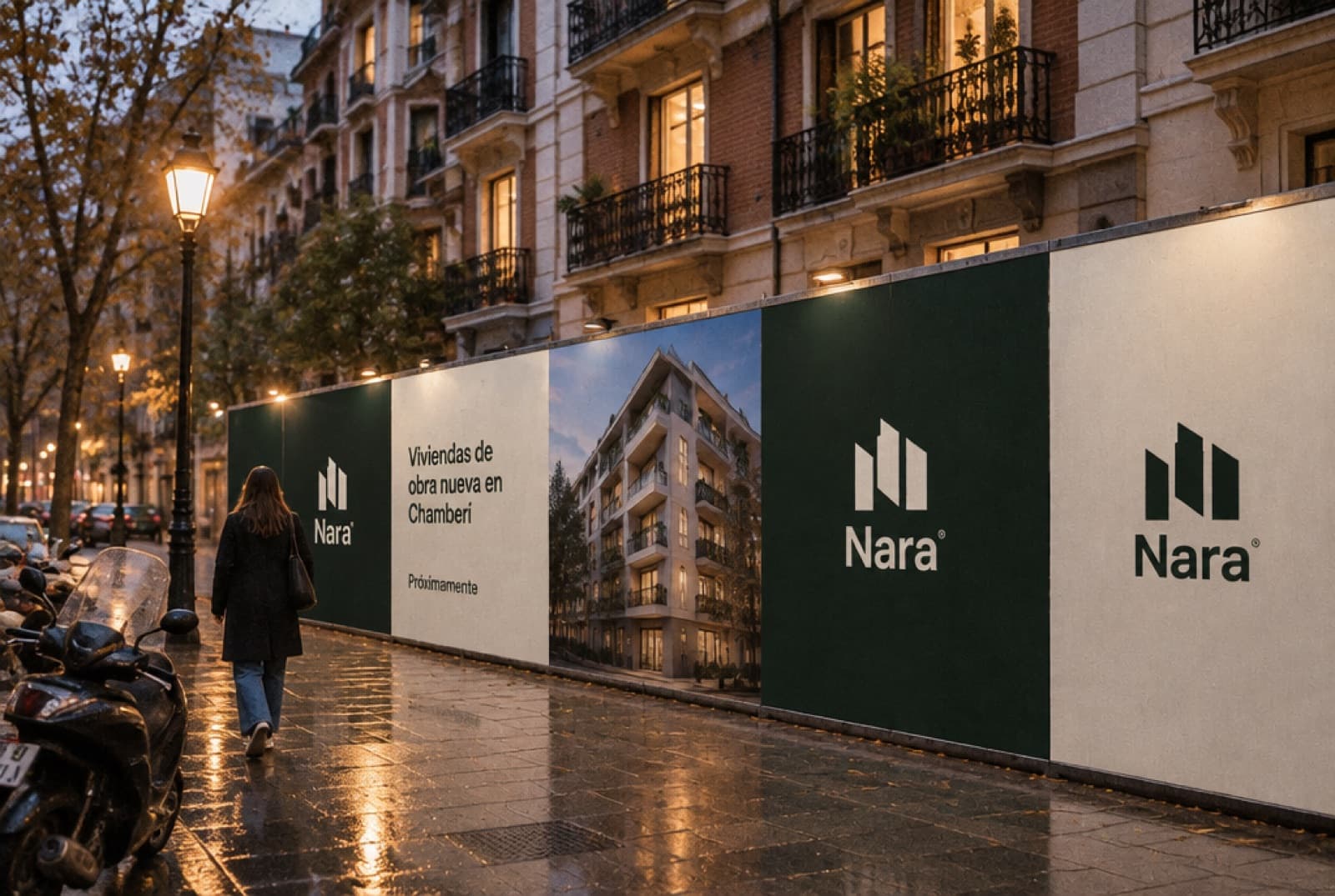 Valla de obra de la promoción en una calle de Madrid al atardecer